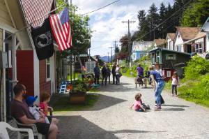 Tenakee Springs residents celebrate the debut of a new seaplane serving the community and other parts of Southeast Alaska during a cookout on June 9, 2021. The town’s post office, left, was forced to close temporarily in recent days because there was no staff, although a visiting employee is now helping one or two days a week. It’s one of a number of short- and long-term problems the tiny island town is facing as it tries to cope with an ageing and shrinking permanent population, as well as more general problems such as worker and supply shortages. (Michael S. Lockett / Juneau Empire File)