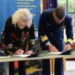University of Alaska Southeast chancellor Karen Carey, left, and Rear Adm. Nathan Moore, commander of Coast Guard District 17, sign a memorandum of agreement for renewal of the College Student Pre-Commissioning Initiative at the college on July 25, 2022. (Courtesy photo / USCG)