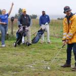 John Cashell prepares to tee off in the rain while the rest of his team, Haley Snell, Marty Stearns, and Josh Pritts, cheered on quietly from behind. (Jonson Kuhn / Juneau Empire)
