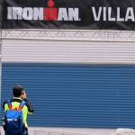 An athlete takes a photo of the Ironman Village sign placed at the entrance of Thunder Mountain High School on Thursday afternoon. (Ben Hohenstatt / Juneau Empire)