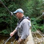 Tenakee Springs Mayor Dan Kennedy looks for salmon in a creek at the edge of town from a bridge that was washed away during a storm in December of 2020 that caused extensive flooding damage throughout the community. In addition to ongoing efforts trying to get disaster relief funds from state and federal officials, Kennedy was among those laboring to rebuild the bridge and numerous other recovery projects. (Mark Sabbatini / Juneau Empire)