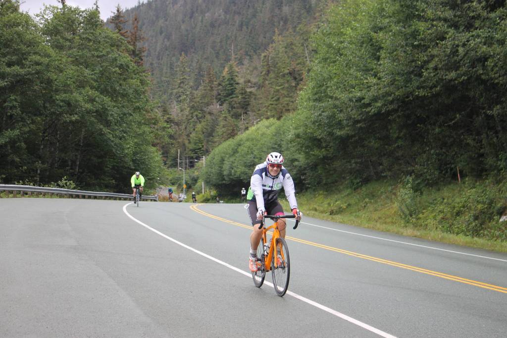 A racer smiles mid way through the 112-bike portion of the Ironman Alaska. (Clarise Larson/ Juneau Empire)