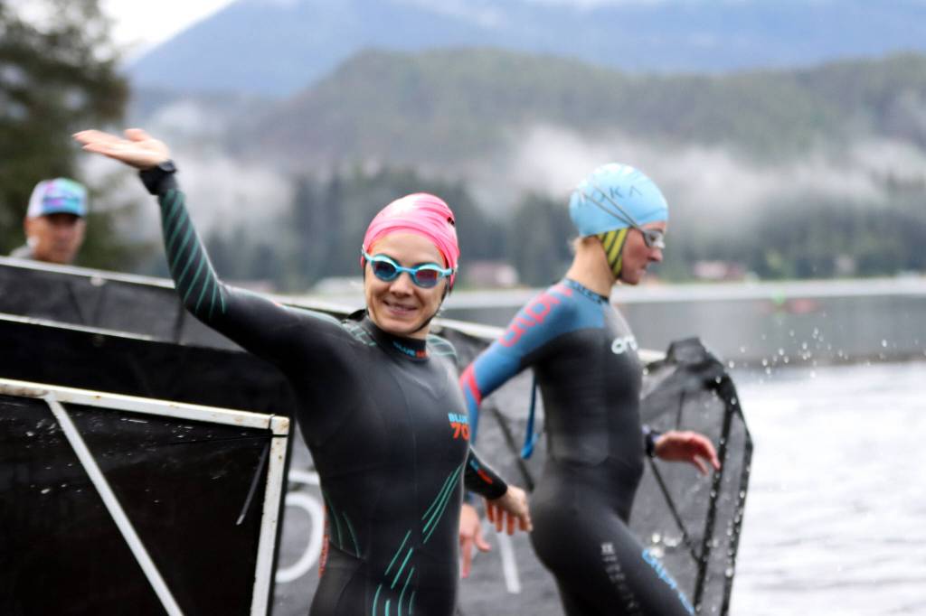 Kara Hollatz of Juneau waves to supporters before going for a 1.2-mile swim in Auke Lake shortly after 6:30 a.m. Sunday. (Ben Hohenstatt / Juneau Empire)