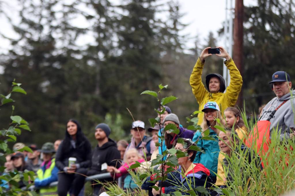 Spectators watch Ironman Alaska athletes swim from the relatively dry shore of Auke Lake. While drizzle started shortly before 9 a.m., there was no rain at 6:30 a.m. as the race began. (Ben Hohenstatt / Juneau Empire)