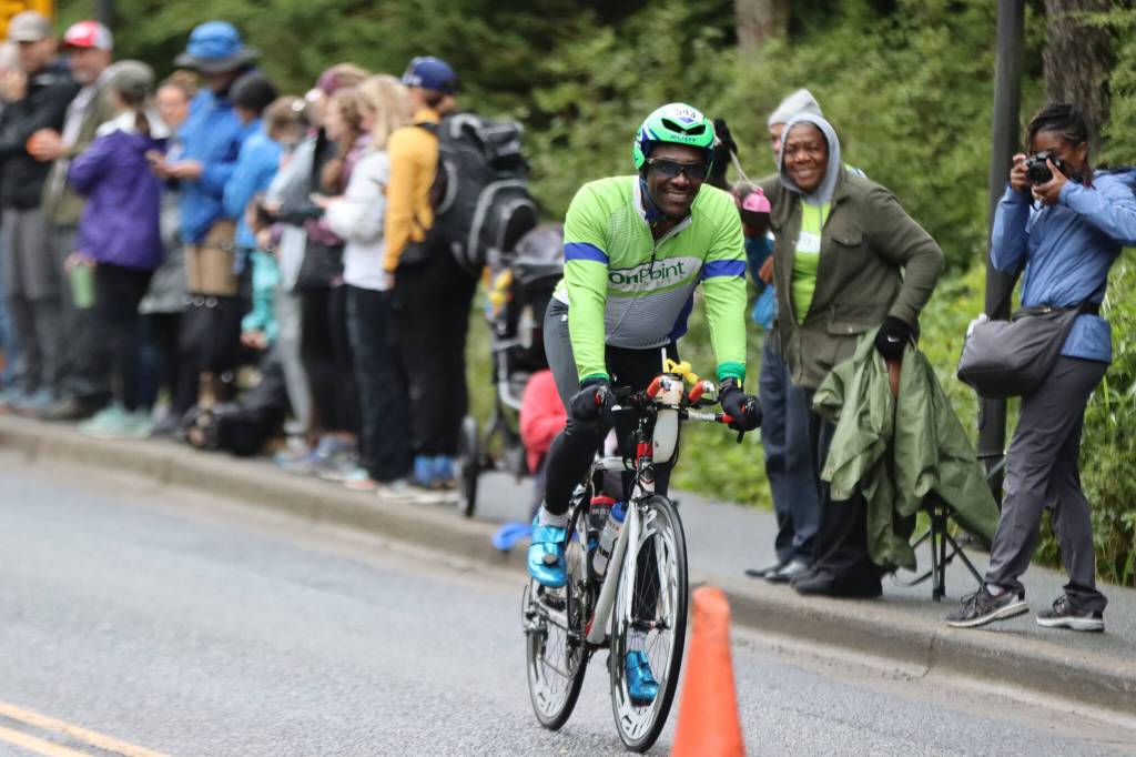 Lloyd Henry of Washington, D.C., smiles while he bikes past his family, including his wife, Marsha Henry, who photographed him. His father, Dr. Lloyd Henry, and mother, Carolyn Henry, traveled from the U.S. Virgin Islands to support their son, who has completed 30 Ironman events and on six continents. (Ben Hohenstatt / Juneau Empire)