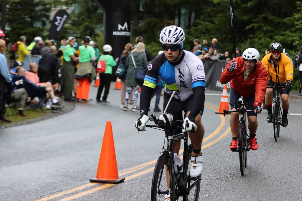 Stephen Sweeney (614), Joel Wendell (124) and Adam Thalhofer (766) bike away from the University of Alaska Southeast campus and out the road Sunday during Ironman Alaska. (Ben Hohenstatt / Juneau Empire)