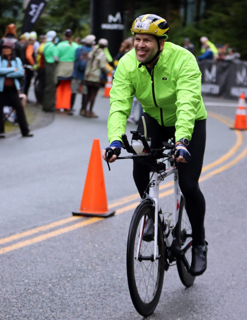 Jeff Zillmer smiles at his traveling supports near the beginning of the bike leg of Ironman Alaska. Zillmer was among a quartet of athletes from North Carolina who traveled to Juneau for the event. (Ben Hohenstatt / Juneau Empire)