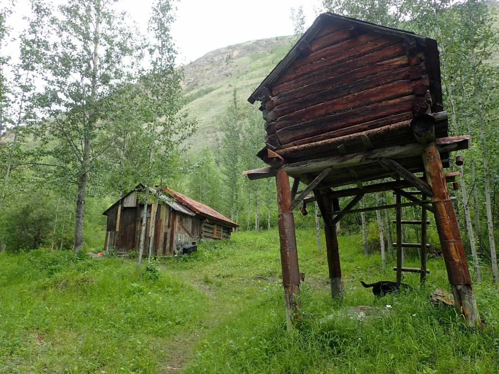 A cache, at right in photo, is an elevated structure northerners use to keep food and other supplies away from dogs and wild animals. (Courtesy Photo / Ned Rozell)