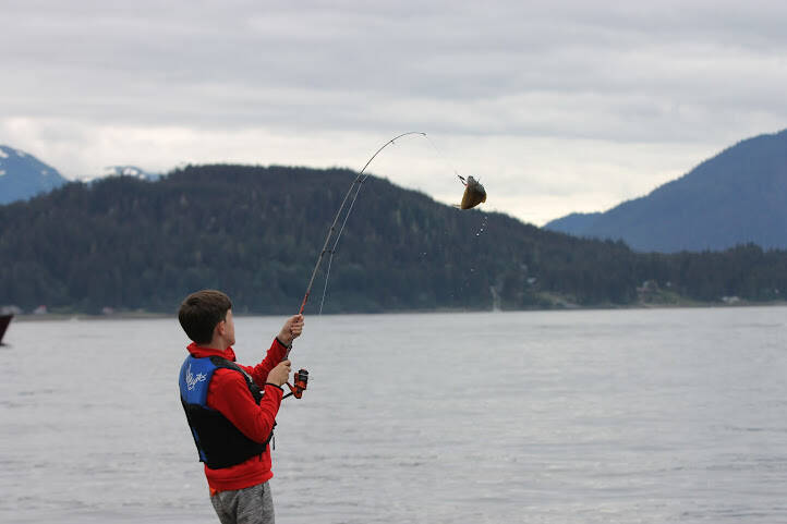 Jaxon Sipniewski catches a flounder on the Auke Nu cove dock. He joined his grandmother, JoAnn Birt, as she volunteers at the weigh-in station. (Clarise Larson / Juneau Empire)