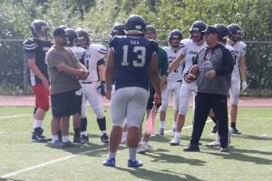Juneau senior Sam Sika is seen in this photo joining the huddle for coach Sjoroos pep talk during practice. Sika and the rest of Huskies defense came up big on Saturdays season opener against the Dimond Lynx in Anchorage. (Jonson Kuhn / Juneau Empire)