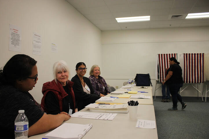 Election official sit by the polling booths at the Mendenhall Mall precinct to help voters with any questions or confusion for this years elections for Alaskas open U.S. House seat and a pick-one primary for U.S. Senate. (Clarise Larson / Juneau Empire)