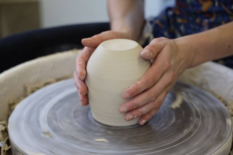 Mercedes Muñoz shapes a ceramic pieces on her potters wheel at her studio. (Clarise Larson / Juneau Empire)