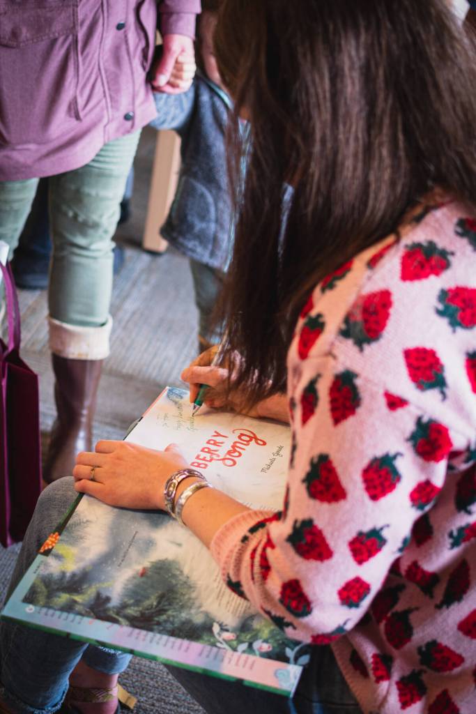 Michaela Goade signs copies of Berry Song at her first event for the picture book.On Aug.6, through a partnership with First National Bank Alaska, Sitka Public Library, Sitka Conservation Society, and the Sustainable Southeast Partnership with support from Hames Corporation and Our Town Catering, Goade and partners hosted her first Berry Song event. Goade read to an overflowing library and volunteers helped hand out 90 signed copies of Berry Song. (Courtesy Photo / Lione Clare)