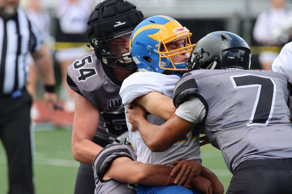 Juneau defenders Sage Richards (54) and Jamal Johnson (7) help wrap up a Bartlett ball carrier. Saturday, the Huskies will host the West Anchorage High School Eagles. Varsity kickoff is scheduled for 3 p.m. (Ben Hohenstatt / Juneau Empire)