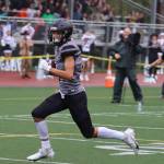 Jayden Johnson makes his way toward the end zone to put the Huskies on the board as teammates and fans celebrate. Johnson also had a late interception that helped seal a win over West Anchorage High School. (Ben Hohenstatt / Juneau Empire)