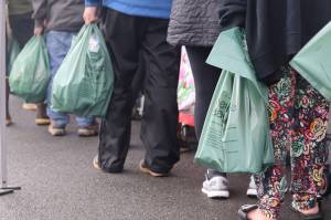 Jonson Kuhn / Juneau Empire 
A long line of residents stand with bags in hand, digging through scarce supplies on a rainy Tuesday afternoon in Juneau at the Southeast Alaska Food Bank.