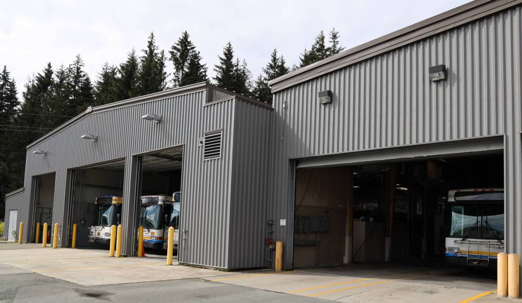 Buses line the open garage doors of the City Borough of Juneau Capital Transits bus barn on Tuesday afternoon. Seven new electric buses will replace old diesel burning buses being used by the city. (Clarise Larson / Juneau Empire)