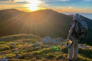 The author looks over a mountain near Ketchikan in the late evening sun on an alpine deer hunt. (Courtesy Photo / Abby Lund)