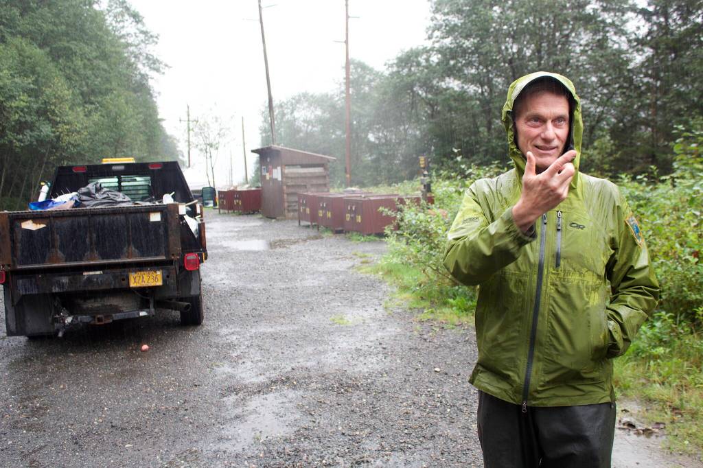 Dale Gosnell, a city parks ranger, explains Monday how essential services are provided at Mill Campground, including the locking bear-proof contains and fresh water tanks behind him. He spent the weekend loading trash and other discard items, including hypodermic needles, into his work truck as part of the routine maintenance duties at the site. (Mark Sabbatini / Juneau Empire)