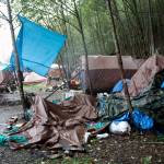 Trash, debris and abandoned belongings are strewn among occupied tents at the Mill Campground on the mountainside across from the cargo ship terminal in downtown Juneau on Monday. The campsite has been at or beyond full capacity through the summer, as have other facilities for the homeless, due to various problems including skyrocketing housing costs and lack of vacancies even for people able to pay at least some rent. (Mark Sabbatini / Juneau Empire)