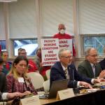 Sean Parnell, a former Alaska governor and current chancellor at the University of Alaska Anchorage, discusses partnerships with local schools and other community groups during the University of Alaskas Board of Regents meeting Thursday at the University of Alaska Southeast. In the background employees with the facultys union hold up signs protesting a stalemate in contract negotiations that has lasted more than a year. The two-day meeting continuing Friday is the boards first in Juneau since 2018. (Mark Sabbatini / Juneau Empire)