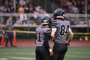 Jarrell Williams (1) and Thomas Baxter (84) celebrate a big play on defense early in Juneau's win over the visiting West Valley Rams. (Ben Hohenstatt / Juneau Empire)