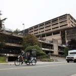 A cycle rickshaw passes the North State Office Building parking garage located on Willoughby Avenue in downtown Juneau. The City and Borough of Juneaus Assembly passed an ordinance unopposed Monday night that gave the OK for the appropriation of $5 million to go toward partially funding the planning and construction of additional parking levels. (Clarise Larson / Juneau Empire)