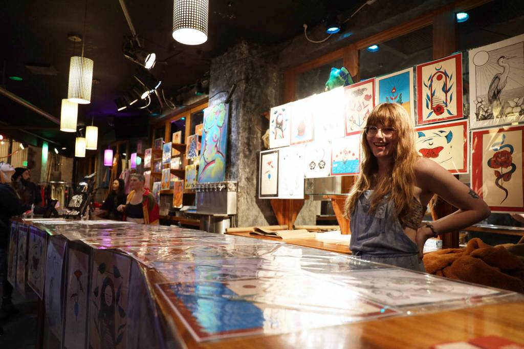 Harper Joy Gunn stands surrounded by her artwork at the entrance of the makers market. The BABEFEST series spans four nights at the crystal saloon and features local artists and musicians. (Clarise Larson / Juneau Empire)