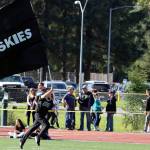 A student runs while holding a Juneau Huskies flag during a home game. Juneau will host Service High School for senior night on Saturday. Varsity is set for a 3 p.m. kickoff. Junior varsity plays at noon. (Ben Hohenstatt / Juneau Empire File)