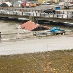 A home that was knocked off its foundation and floated down Snake River during a severe storm in Nome, Alaska, is caught under a bridge Saturday, Sept. 17, 2022. Much of Alaskas western coast was battered by the storm, which was the remnant of Typhoon Merbok, causing the most damage of any storm in the last half century. (AP Photo/Peggy Fagerstrom)