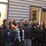 Guest speakers and members of the community gathered after the vigil to hang signs and photos in the window of the SEARHC Front Street Clinic to remember and honor loved ones lost to substance abuse. The display remains visible for the public to view. (Jonson Kuhn / Juneau Empire)