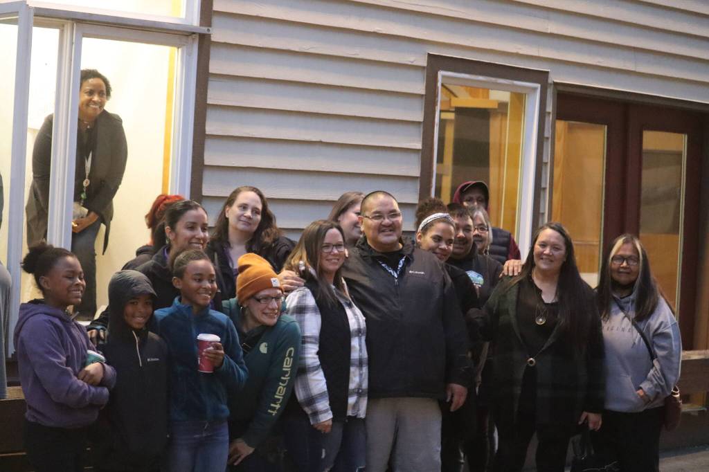 Guest speakers and members of the community gathered after the vigil to hang signs and photos in the window of the SEARHC Front Street Clinic to remember and honor loved ones lost to substance abuse. The display remains visible for the public to view. (Jonson Kuhn / Juneau Empire)