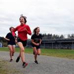 From left to right, Thunder Mountain High School cross country runners Randy Stichert, Piper Blackgoat and Kobe Yturbe finish up their run at cross country practice on Monday afternoon. (Clarise Larson / Juneau Empire)