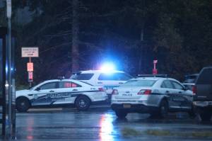 Several police vehicles, including a mobile incident command vehicle, were present Wednesday evening near the Kaxdigoowu Héen Dei (Brotherhood Bridge Trail) trailhead. (Ben Hohenstatt / Juneau Empire)