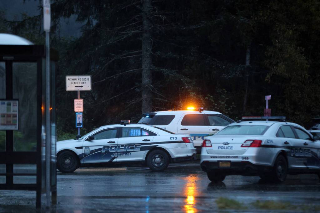 Police vehicles gather Wednesday evening near Kaxdigoowu Héen Dei, also known as ]]Brotherhood Bridge Trail, while investigating what police have described as a suspicious death. (Ben Hohenstatt / Juneau Empire)