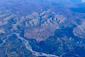 A vegetated sand dune that formed between the Tanana River, Interior Alaska hills and the Taylor Highway, as seen from a flight from Seattle to Fairbanks. The Alaska Highway Bridge over the Tanana River is visible at bottom. (Courtesy Photo / Ned Rozell)