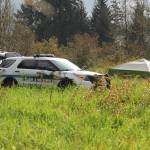 On Thursday morning, JPD Officer Austin Thomas and Officer Taylor Davis walk the fielded area which was blocked off by crime scene tape. Multiple tents and a police vehicle sat in the field where the tape surrounded, another police vehicle sat in a dirt parking area. (Clarise Larson / Juneau Empire)