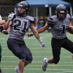 A Lucas White (21) block buys Jarrell Williams (1) more room to work during a 49-32 win against Service High School. (Ben Hohenstatt / Juneau Empire)