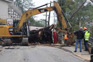City and Borough of Juneau Public Works Department clears debris Wednesday morning on Gastineau Avenue. A landslide Monday evening brought down a large tree, which caused damage to homes and a vehicle. (Jonson Kuhn / Juneau Empire)