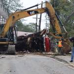 City and Borough of Juneau Public Works Department clears debris Wednesday morning on Gastineau Avenue. A landslide Monday evening brought down a large tree, which caused damage to homes and a vehicle. (Jonson Kuhn / Juneau Empire)
