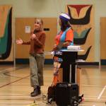 Laura Talpey, executive director of Juneau Montessori School speaks into the mic next to Jamiann Seiltin Hasselquist, vice president of Alaska Native Sisterhood Camp 2 Juneau, in front of a crowd gathered at Sayéik: Gastineau Community School Wednesday evening. (Clarise Larson / Juneau Empire)