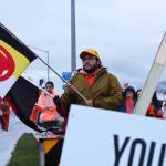 Connor Ulmer holds a flag along Egan Drive for an Orange Shirt Day event. The international day remembers lives lost in the boarding school system and the profound impact systematic forced assimilation has had on Indigenous peoples. (Ben Hohenstatt / Juneau Empire)