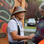 Tlingit master carver Wayne Price shakes hands with community members after the ceremony. Price has been a carver since 1971, and has carved dozens and dozens of totem over the decades. (Clarise Larson / Juneau Empire)