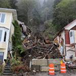 Clarise Larson/ Juneau Empire
Two cones and concrete barriers sit near the fallen trees and debris left over after a landslide occurred early last week. Officials determined in the aftermath of the event that the landslide occurred predominantly due to a large tree that fell and in the process pulled down mud and other debris with it as it slid down the hillside.