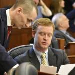 Reps. Clavin Schrage, I-Anchorage, left, and David Eastman, R-Wasilla, discuss a bill on the floor of the Alaska House of Representatives to enact limits on individual contributions to political campaigns, on Monday, March 14, 2022. (Peter Segall / Juneau Empire File)