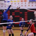 TMHS Kaidree Hartman spikes the ball during an away match against Juneau-Douglas High School: Yadaa.at Kalé while her teammates Mallory Welling (2) and Ashlyn Gates (5) look on with anticipation. JDHS Ashley Laudert gets ready to dig the ball. (Ben Hohenstatt / Juneau Empire File)