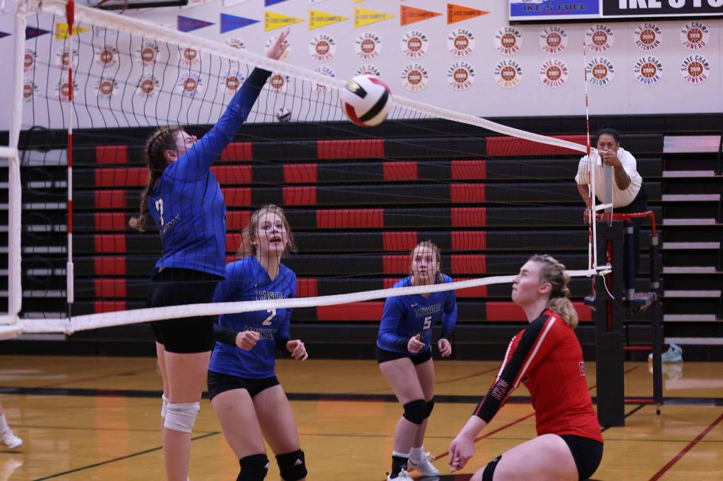 TMHS Kaidree Hartman spikes the ball during an away match against Juneau-Douglas High School: Yadaa.at Kalé while her teammates Mallory Welling (2) and Ashlyn Gates (5) look on with anticipation. JDHS Ashley Laudert gets ready to dig the ball. (Ben Hohenstatt / Juneau Empire File)