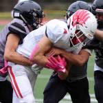 Jayden Johnson, Jamal Johnson and Chris Harris work together to bring down the ball carrier.
