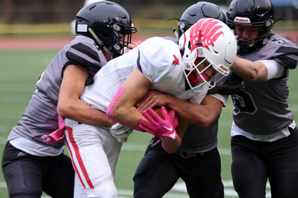 Jayden Johnson, Jamal Johnson and Chris Harris work together to bring down the ball carrier.