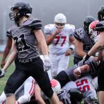 Lucas White (21) tosses the football to the referee after scoring a short rushing touchdown for the Huskies. (Ben Hohenstatt / Juneau Empire)